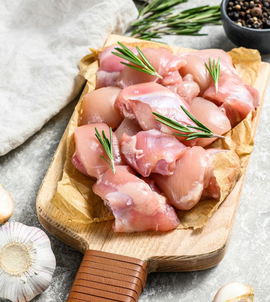 chicken thigh fillet cut into cubes. Gray background. Top view