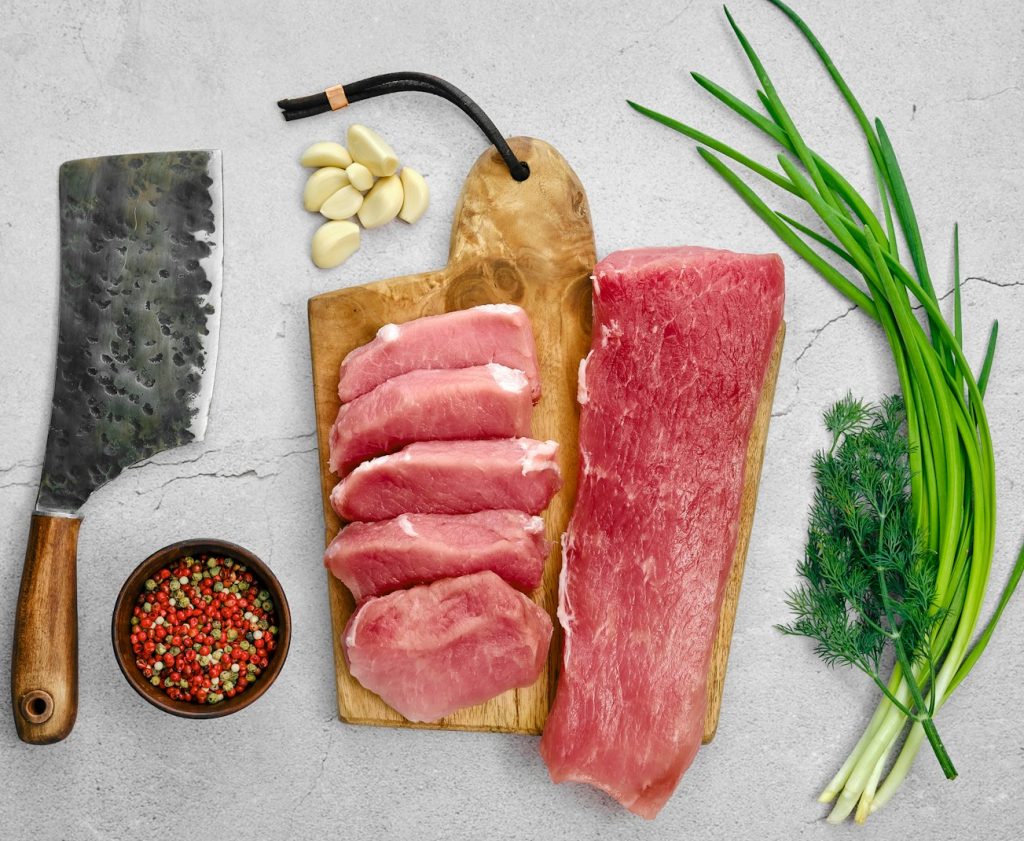 Raw pork fillet and chops on concrete background