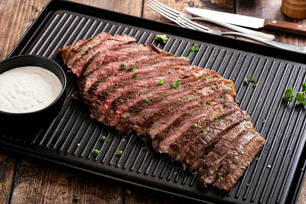 Grilled flank steak with horseradish sauce on a grill pan